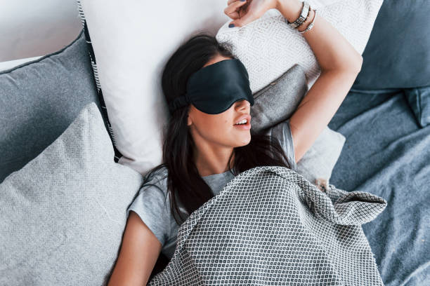 istock Young beautiful woman in lying down on bed at home alone and sleeping 1323669875
