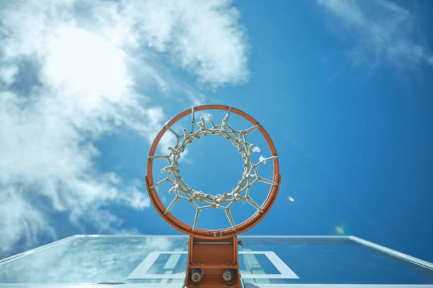 abgeschnittener schuss eines basketballnetzes an einem sonnigen tag draußen - basketball nobody sporting ball stock-fotos und bilder