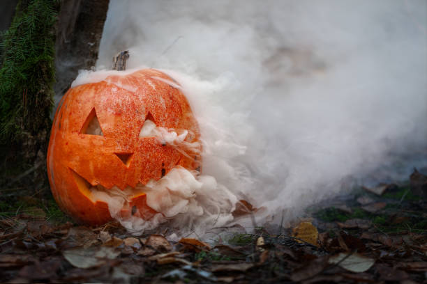 istock Halloween pumpkin in the dark spooky forest with ghost smoke 1323673147
