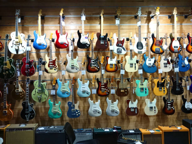 wand voller hängender e-gitarren in verschiedenen farben - musical instrument audio stock-fotos und bilder