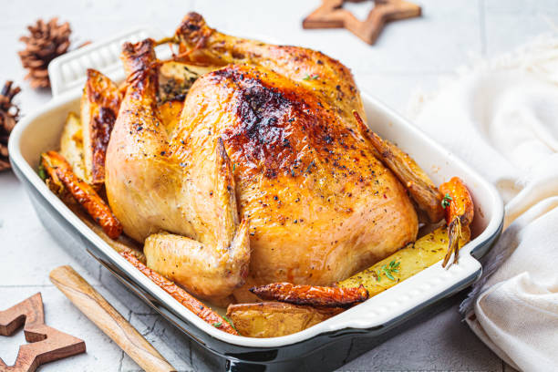 istock Christmas baked whole chicken stuffed with thyme, lemon and vegetables. 1323674250