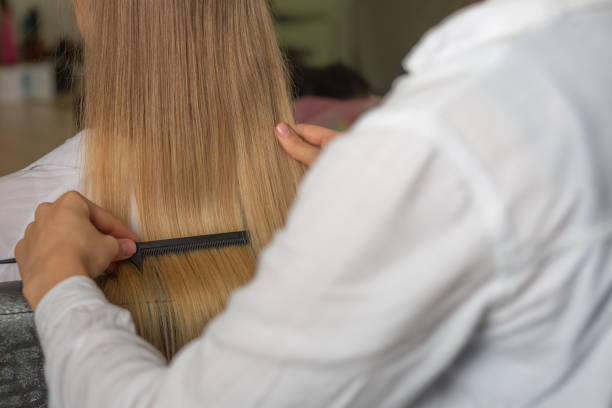 istock Hair stylist combs client's hair before styling 1323676829