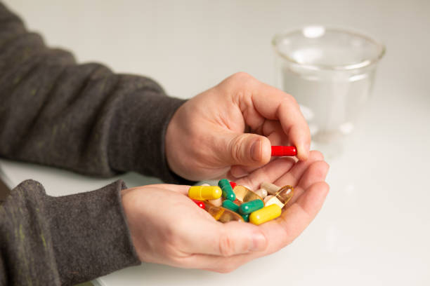 istock Man holding pills and vitamins 1323676888