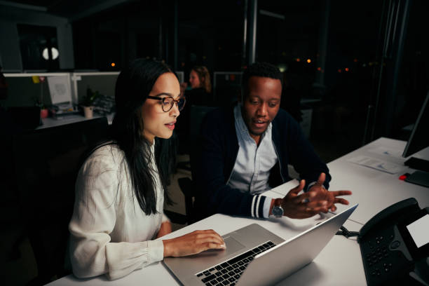 istock Two diverse business people working on project using laptop at modern start up office 1323677185