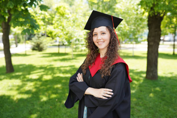 istock successful happy graduating student with nature green background near university. 1323677356
