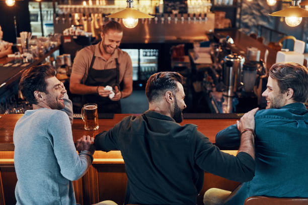 istock Smiling young men in casual clothing drinking beer 1323680072