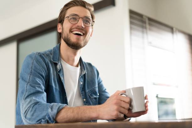 istock Young casual man with mug of tea or coffee in kitchen. 1323681163