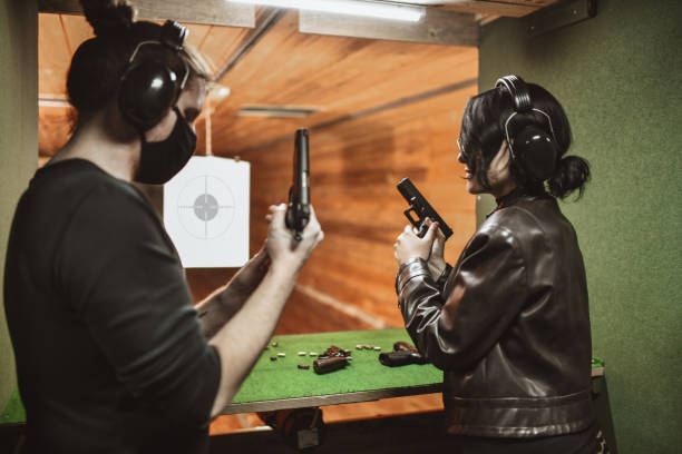 istock Male Instructor With Face Mask Showing Female Student How To Properly Load Gun 1323681927