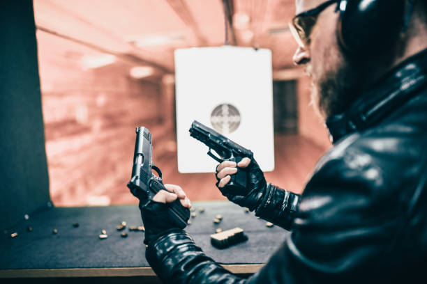 istock Bearded Comparing Metal To Polymer Frame Firearms On Gun Range 1323682042