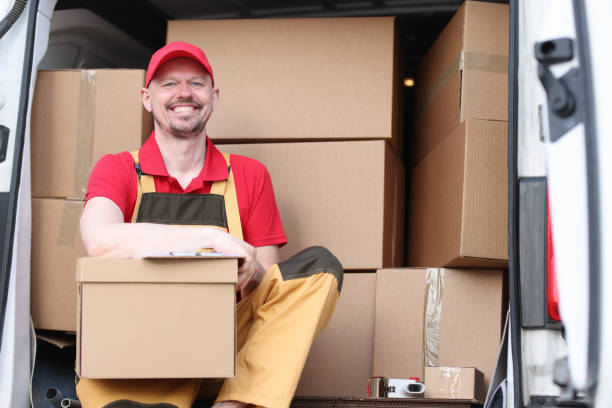 istock Male courier sitting in car with cardboard boxes and documents 1323683540