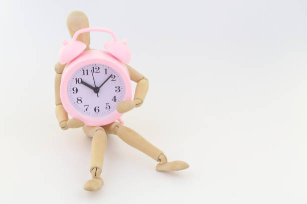 istock Wooden mannequin holding alarm clock 1323684102