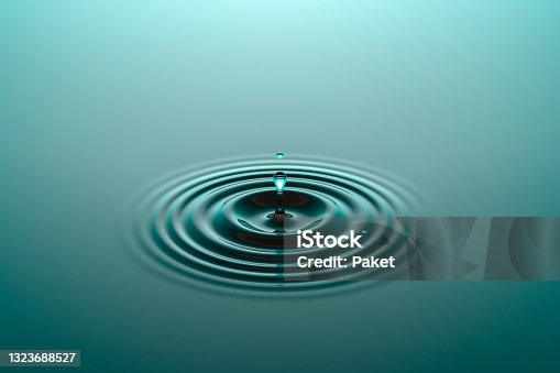 istock Water drop falling into water surface with ripples 1323688527