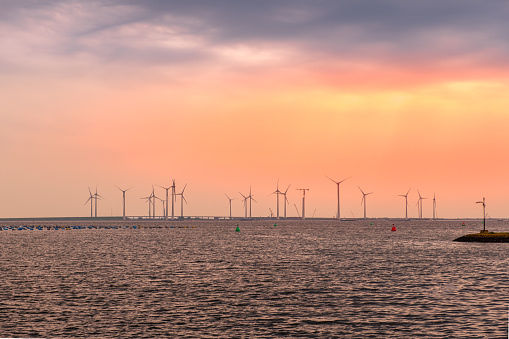 Sunrise over a field of wind turbines at the Krammer sluices near Bruinisse in the province Zeeland in The Netherlands.