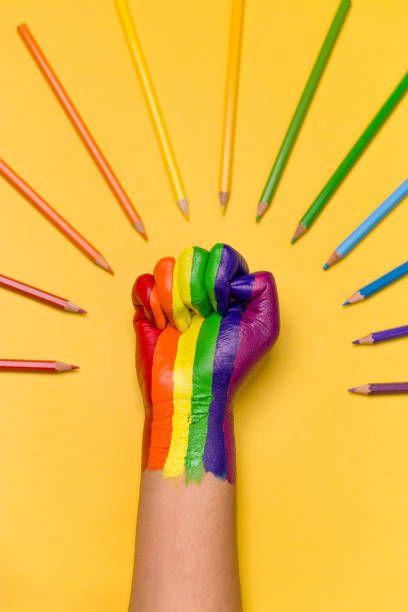 lgbtqコミュニティのための虹色で着色された上げられた拳の写真。 - anti sex ストックフォトと画像