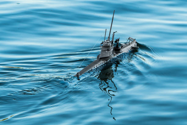 Submarine model swimming on blue wavy water surface on lake
