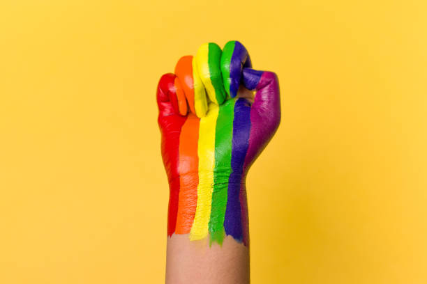 lgbtqコミュニティのための虹色で着色された上げられた拳の写真。 - anti sex ストックフォトと画像