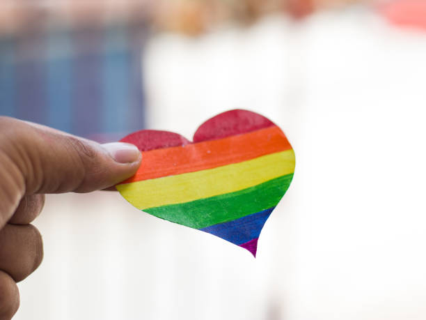 lgbtqコミュニティのために手元に虹色のハート。 - anti sex ストックフォトと画像