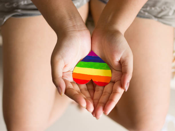 lgbtqコミュニティのために手元に虹色のハート。 - anti sex ストックフォトと画像