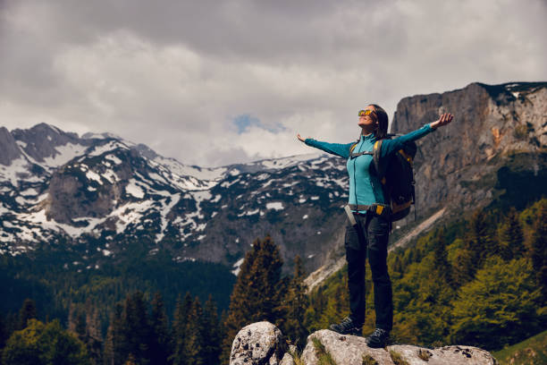 istock Young woman backpacker enjoying the view at mountain peak 1323690216