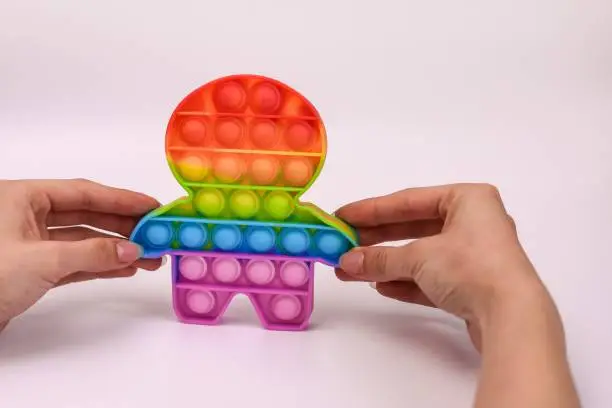 Photo of hands holding a colored toy antistress pop it