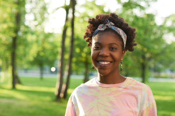 istock African woman standing in the park 1323694621