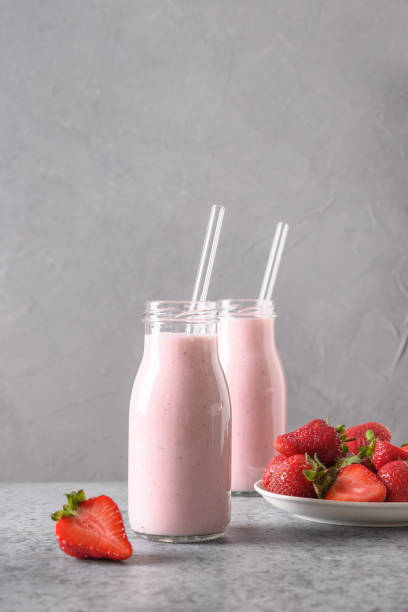 istock Indian strawberry lassi or milkshake in bottle on gray. 1323694727