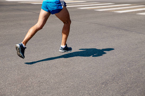 istock legs male runner run on gray asphalt marathon 1323695654