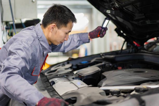 istock Car maintenance worker holding a flashlight to inspect the engine compartment 1323696618