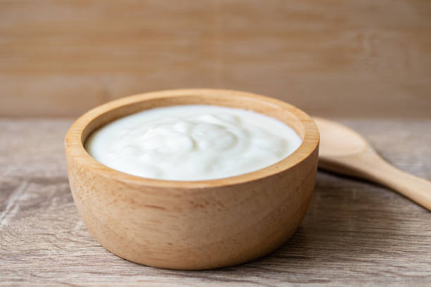 istock White yogurt in a wooden cup with a wooden spoon 1323698143