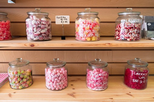 A selection of sweets in clear glass jars on a shelf in a plastic free store.