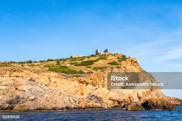 Ancient Ruins Of Temple Of Poseidon On The Cliff Sounion Distant View From The Sea In Sunny Summer Day With Crystal Blue Sky Greece Stock Photo - Download Image Now