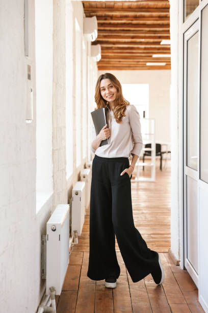 istock Smiling young business woman holding folder 1323701763