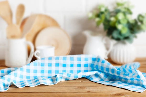 istock Napkin checkered tablecloth on brown wooden kitchen table. Blur rye bokeh background. Selective focus. Place for food and drink. 1323704863