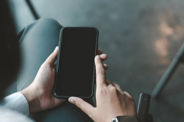 istock Close-up  Businessman hands sitting at work holding a smartphone. 1323705087