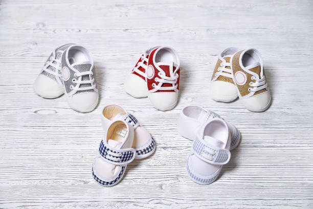 istock multi-colored children's shoes on a white-gray non-uniform wooden background 1323710102