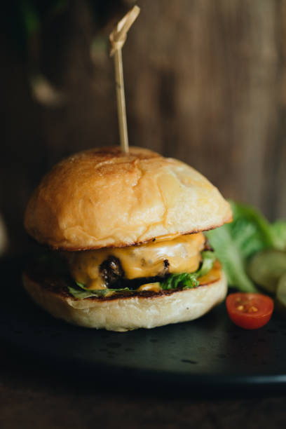 istock Fresh tasty burger on old dark wooden table 1323710759