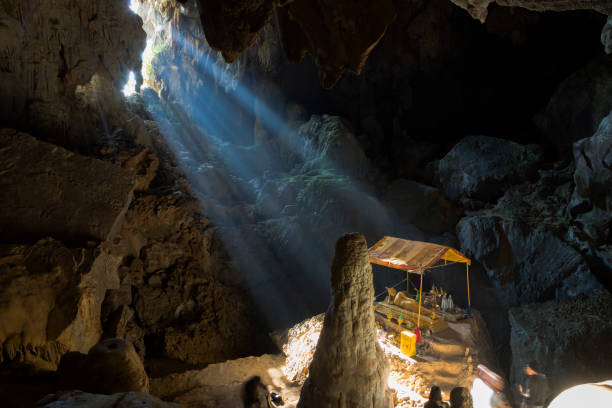 raggi del sole al tramonto che entrano nella grotta di phu kham, laos - vang vieng foto e immagini stock