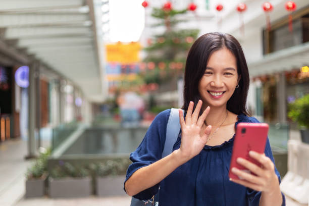videollamada mujer con teléfono móvil en el paisaje urbano - correspondence waving horizontal outdoors fotografías e imágenes de stock