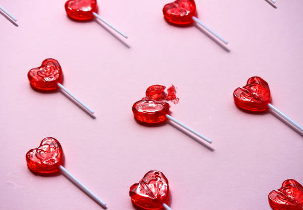 Heartbreak Generic unbranded heart lollipops on pink background. Concept 'broken heart', 'Breakup', 'Single' relationship status. broken heart stock pictures, royalty-free photos & images