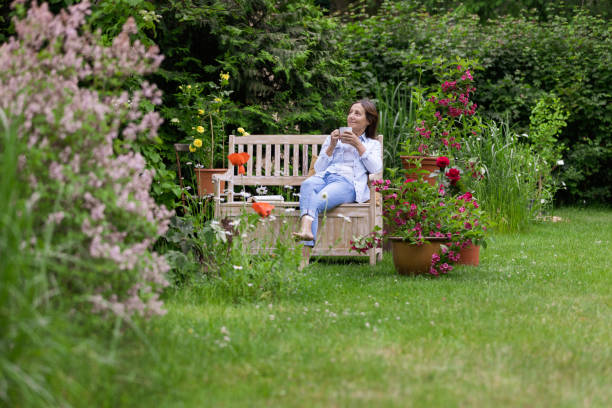 jardinería - la mujer disfruta de relajarse en el jardín - summer people furniture vacations fotografías e imágenes de stock