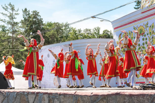 dziecięcy zespół tańca ludowego występuje na otwartej scenie w parku miejskim. - costume stage costume sunlight carnival zdjęcia i obrazy z banku zdjęć