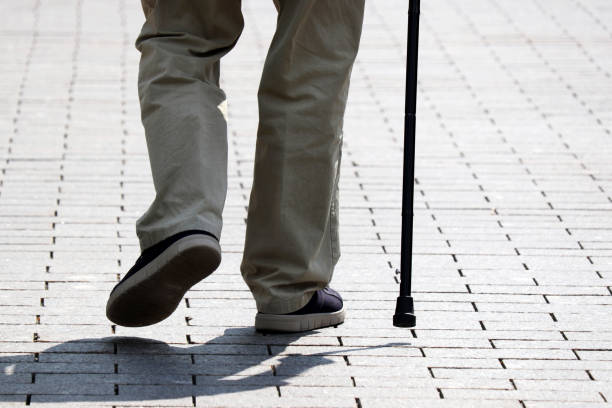 istock Man walking with a cane down the street 1323724728