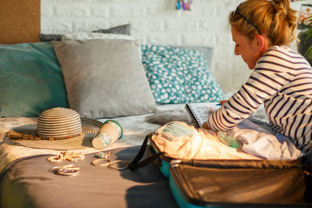 istock Woman checking off the list while packing a suitcase 1323730168