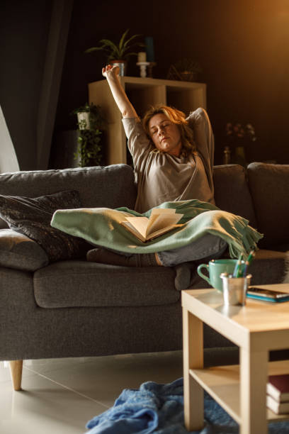 istock Woman stretching after reading a book late at night 1323730734