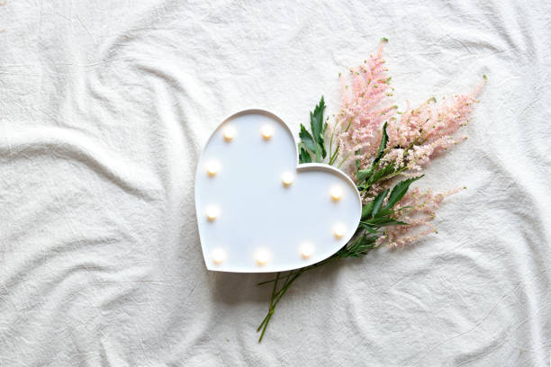 istock Heart lightbox and wild flowers . Flat lay on off white textile. Natural materials, environment concious, low impact lifestyle. Pale pink Prachtspiere flower 1323730788