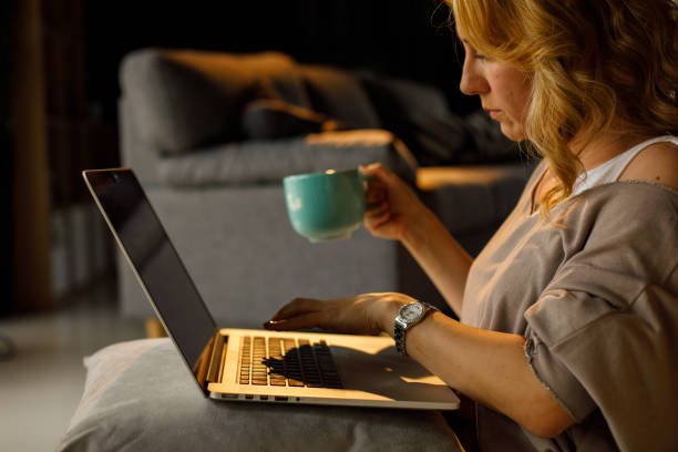 istock Woman working late, using laptop and drinking coffee 1323733480