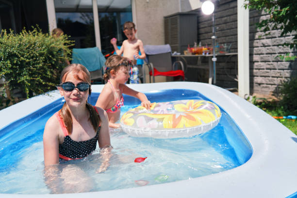 istock Backyard Water Fun Cute Little Kids Playing in Swimming Pool 1323733877
