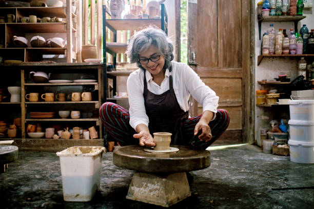 femmes moyennes travaillant sur la fabrication d’objets en argile dans l’atelier de poterie - groupe moyen dobjets photos et images de collection