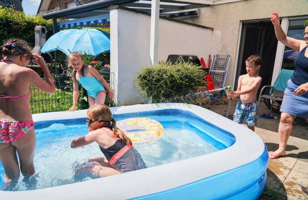istock Backyard Water Fun Cute Little Kids Playing in Swimming Pool 1323734343
