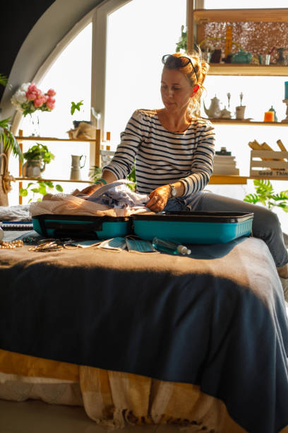istock Woman packing clothes in suitcase, getting ready for a vacation 1323734986